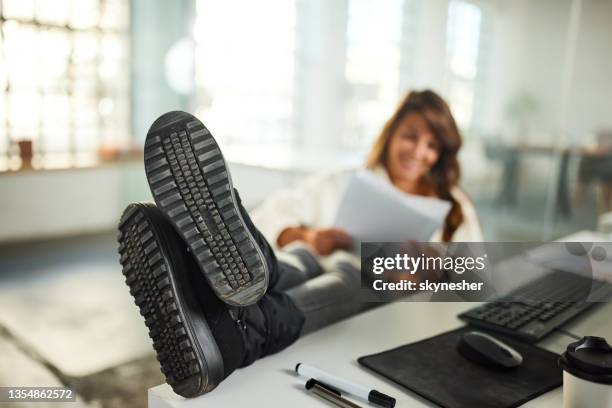 resting feet on a desk in the office! - female soles stockfoto's en -beelden