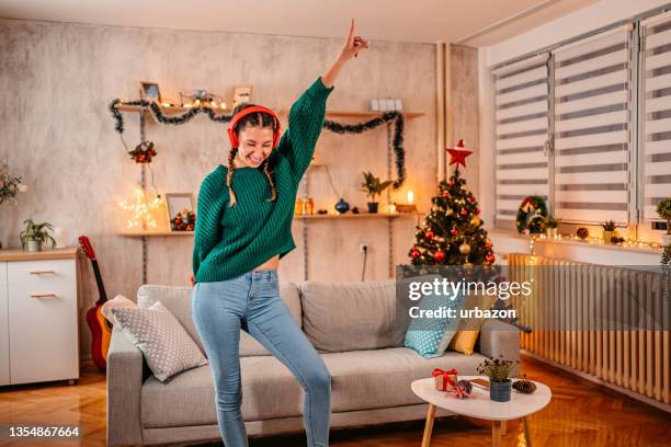 frau, die zu weihnachten zu hause singt und tanzt - karaoke anlage stock-fotos und bilder