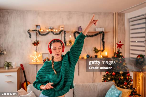 woman singing and dancing at home at christmas - singing imagens e fotografias de stock