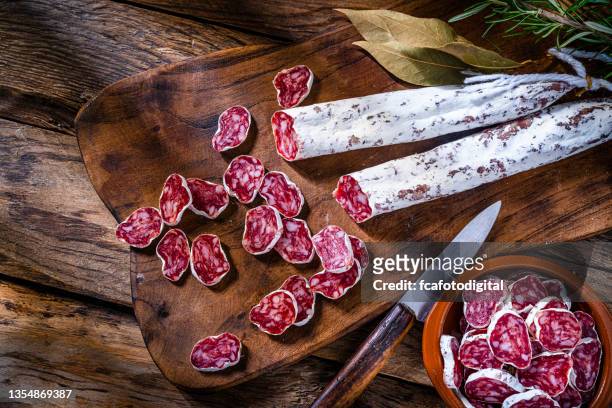 spanish chorizo or fuet on rustic table. top view - salami stock pictures, royalty-free photos & images