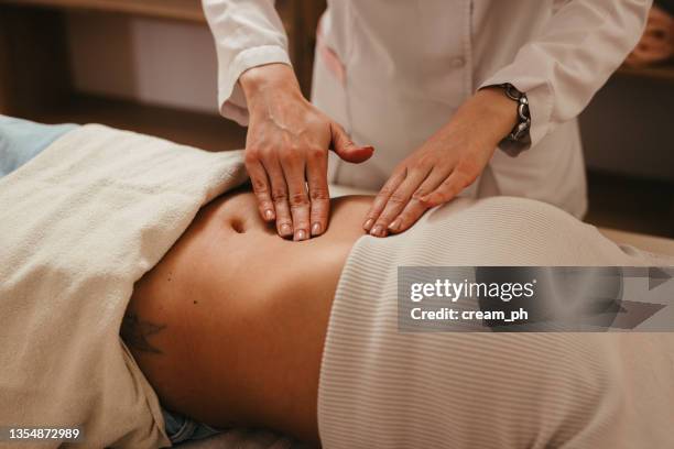 woman having acupuncture treatment on her stomach - doctor abdomen stock pictures, royalty-free photos & images