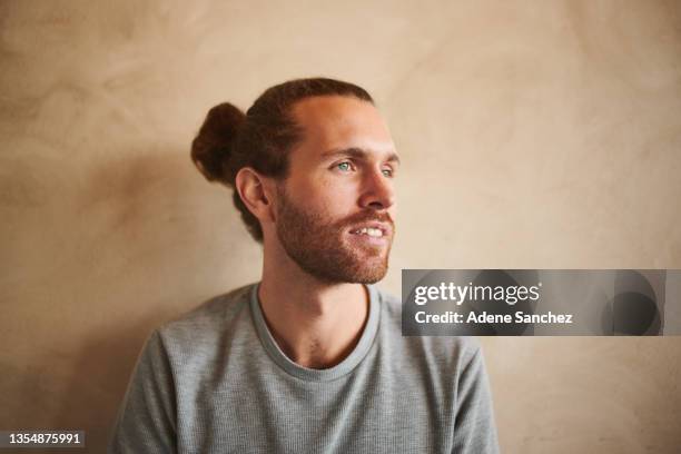 shot of a young man sitting against the wall - see far stock pictures, royalty-free photos & images