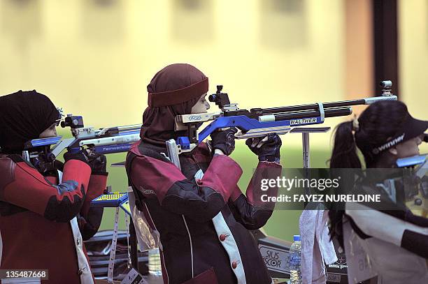 Arab Athletes compete in the women's 10M air rifle competition at the Lusail Shooting Complex in Doha during the 2011 Arab Games in the Qatari...