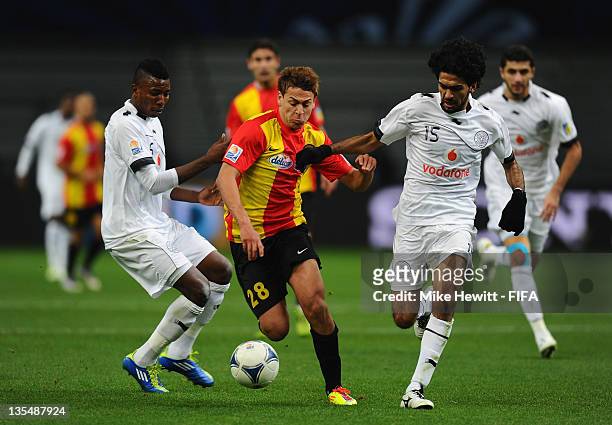 Youssef Msakni of Esperance is challenged by Kasola Mohammed and Talal Albloushi of AL Sadd Club during the FIFA Club World Cup Quarter Final match...