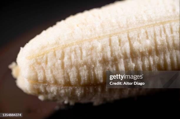 close-up of a peeled banana. black background. - banana split fotografías e imágenes de stock