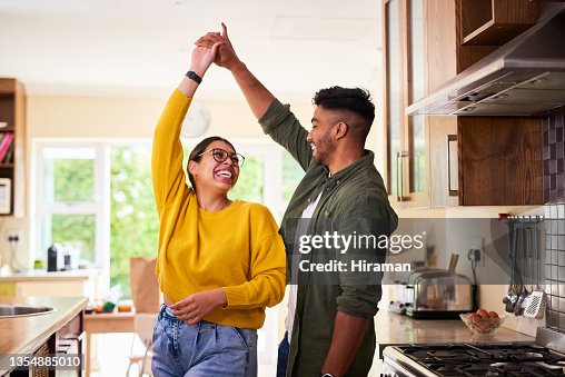 Shot of a young couple dancing together in their kitchen Shot of a young couple dancing together in their kitchen