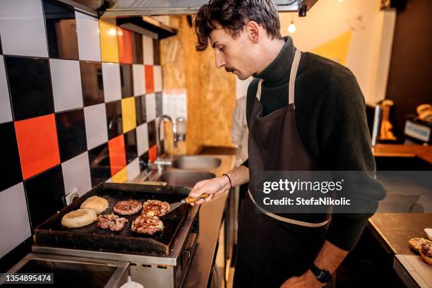 il est dans son élément lorsqu’il cuisine - burger portrait photos et images de collection