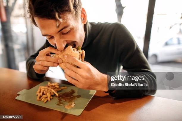 leckerer burger - adults eating hamburgers stock-fotos und bilder