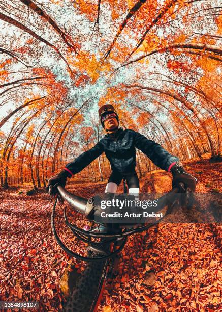 creative selfie picture riding mountain bike in autumn forest in spain. - wide angle ストックフォトと画像