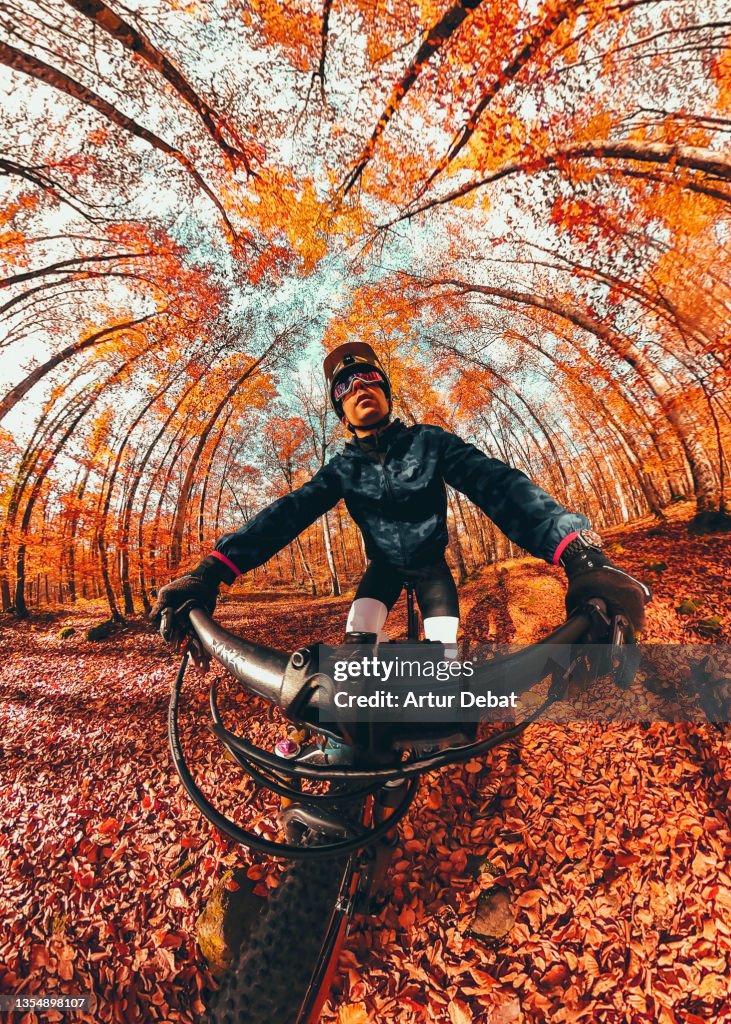 Creative selfie picture riding mountain bike in autumn forest in Spain.