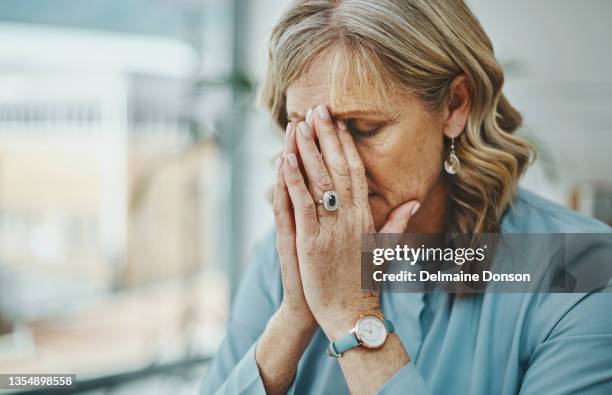 scatto di una donna d'affari matura che sembra stressata mentre lavora in un ufficio moderno - senza speranza foto e immagini stock