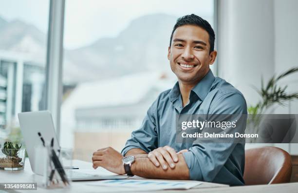 foto de un joven empresario usando una computadora portátil en una oficina moderna - hombre fotografías e imágenes de stock