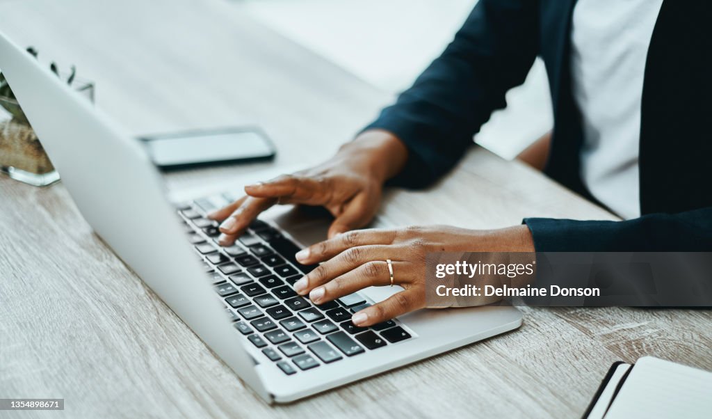 Shot of an unrecognisable businesswoman using a laptop in a modern office