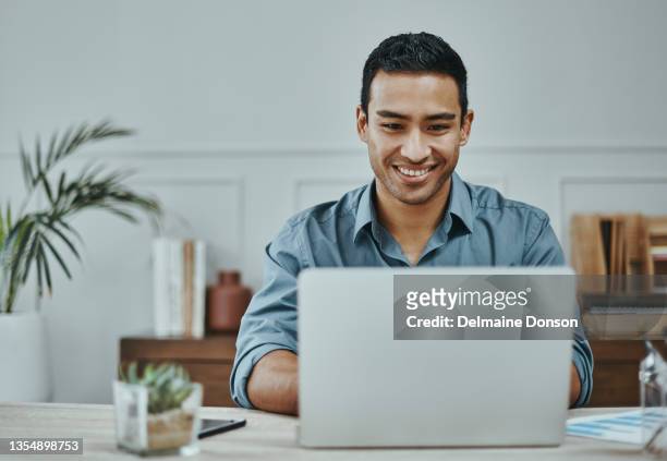 shot of a young businessman using a laptop in a modern office - laptop work search stockfoto's en -beelden
