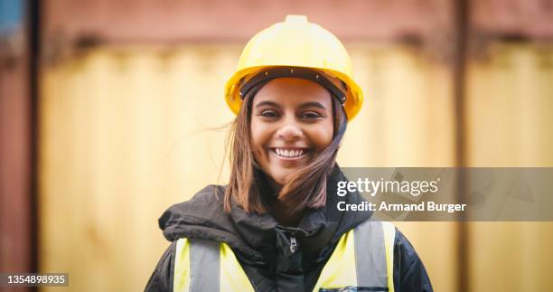 aufnahme einer jungen frau mit schutzhelm bei der arbeit - under construction stock-fotos und bilder