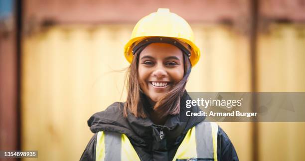 shot of a young woman wearing a hardhat at work - shipyard stockfoto's en -beelden