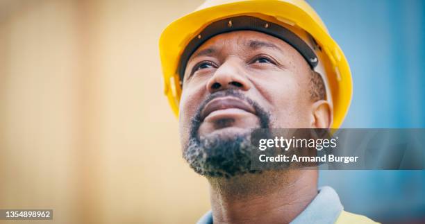 aufnahme eines reifen mannes mit schutzhelm bei der arbeit - dock worker stock-fotos und bilder