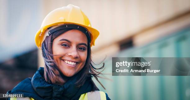 foto de una mujer joven con un casco en el trabajo - casco protector fotografías e imágenes de stock