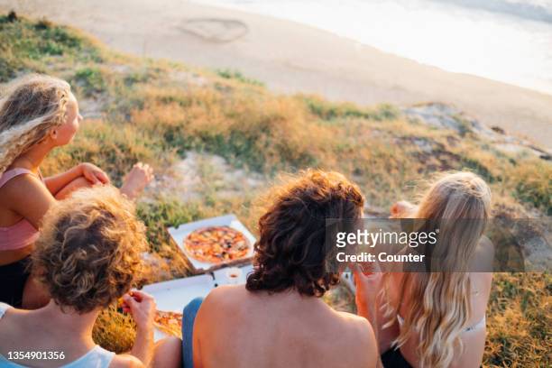 group of friends eating vegan pizza at beach - hossegor ストックフォトと画像