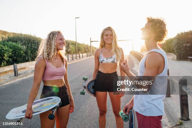 group of friends with skateboards at sunset - hossegor photos et images de collection