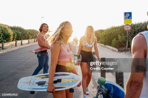 group of friends with skateboards at sunset - hossegor photos et images de collection