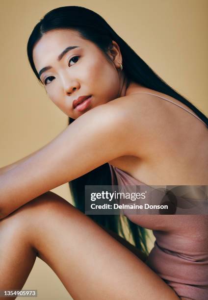 scatto di una giovane donna attraente seduta da sola e in posa in studio - body foto e immagini stock