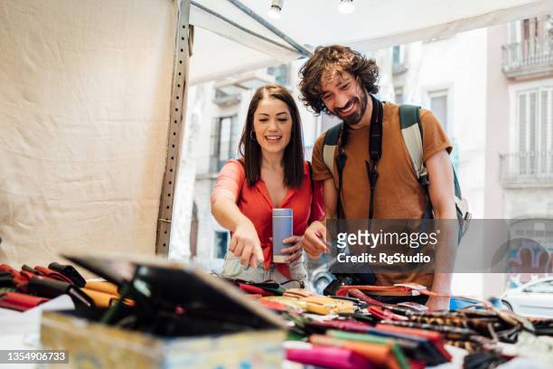 happy young couple buying souvenirs in barcelona - buyer journey stock pictures, royalty-free photos & images