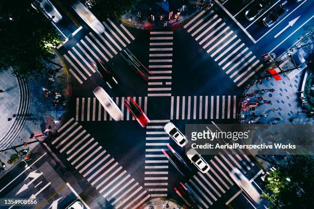 drone point view of city street crossing at night - dwarsweg stockfoto's en -beelden
