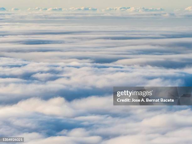 full frame, sea of clouds on a blue sky  in the teide national park. - grey clouds stock pictures, royalty-free photos & images