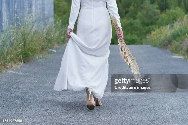 bottom view of bride with her white dress and her bouquet mountain pines - bride walking stock pictures, royalty-free photos & images