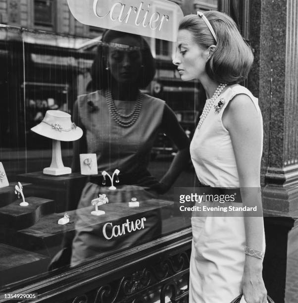 French actress Capucine window shopping at the Cartier jewellery store on Old Bond Street in London, UK, 10th August 1964.