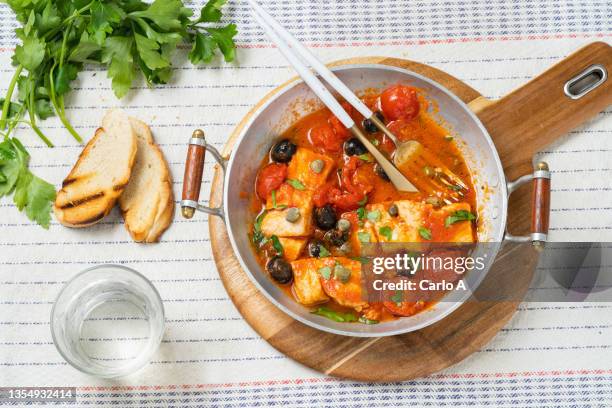 cod fish in tomato sauce and olives - cod dinner stock pictures, royalty-free photos & images