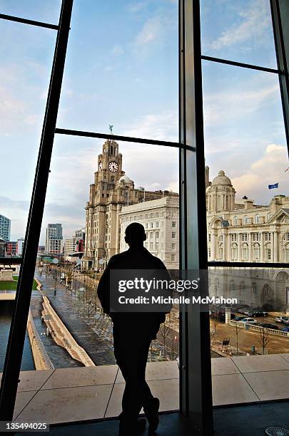 man watching out from window of museum - museum of liverpool photos et images de collection