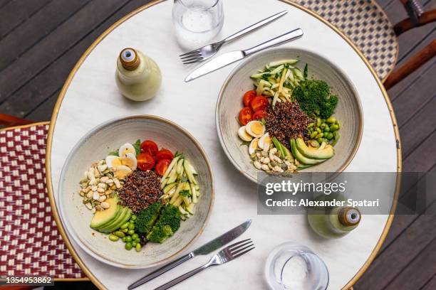 healthy salad bowls on the table at the cafe, directly above view - uovo di quaglia foto e immagini stock