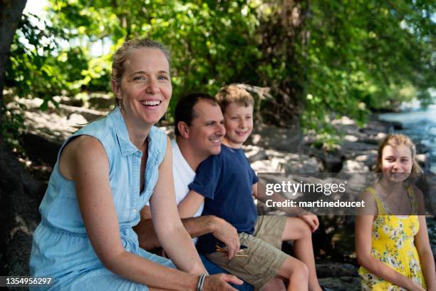 echtes familienporträt von 4 am flussufer im sommer. - real people family portraits stock-fotos und bilder