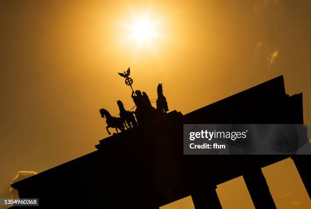 brandenburg gate at sunset (berlin, germany) - quadriga statue brandenburg gate stock pictures, royalty-free photos & images