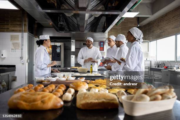 teacher in a baking class explaining to her students how to make bread - bageri bildbanksfoton och bilder