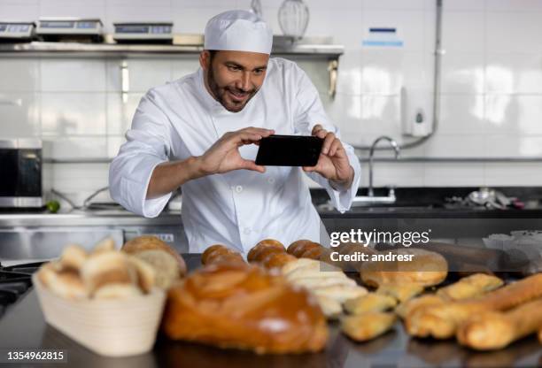 baker taking a picture of the breads he baked - marketing small business stock pictures, royalty-free photos & images