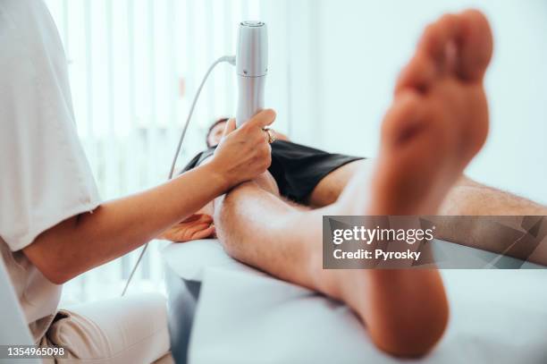 ultraschalluntersuchung des kniegelenks für einen mann mit ultraschallgerät in der klinik - knee surgery stock-fotos und bilder