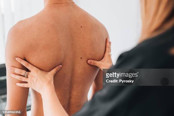 fisioterapeuta examinando la espalda del paciente - escapula fotografías e imágenes de stock
