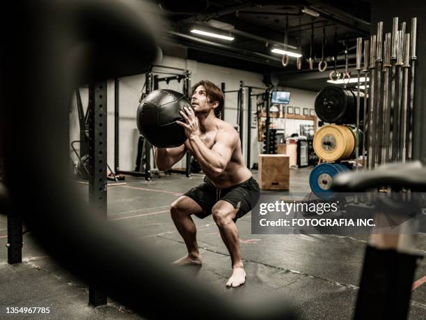 man exercising with beanbag in the gym - training bean bag stock pictures, royalty-free photos & images