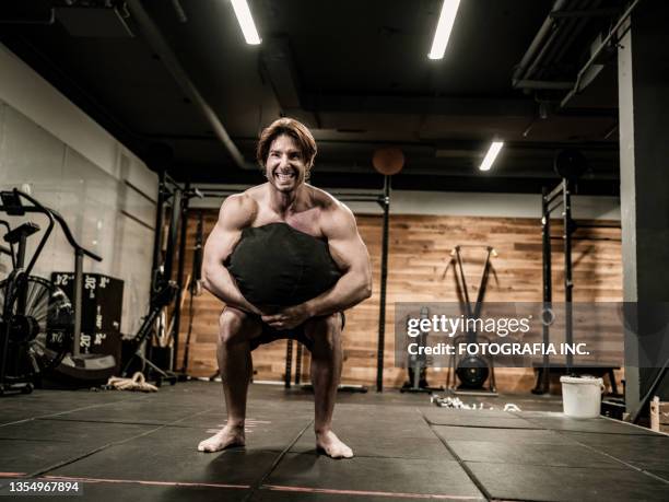 man exercising with beanbag in the gym - training bean bag stock pictures, royalty-free photos & images