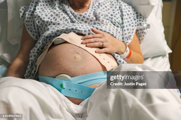 unrecognisable pregnant woman in delivery room getting ready to give birth - giving birth stockfoto's en -beelden