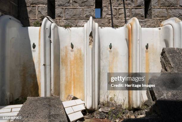 Birnbeck Pier, Birnbeck Island, Weston-Super-Mare, Somerset, 2018. Detail of stained and damaged urinals in the gentlemen's toilets on the derelict...