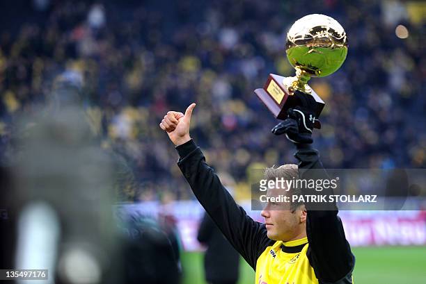 Dortmund's midfielder Mario Goetze holds his Golden Boy 2011 trophy after being awarded the best European under-21 player of the year prior to the...