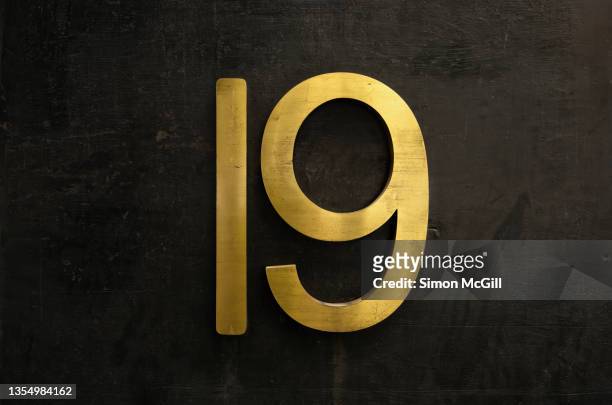 number 19 in brass numerals on a black painted building exterior - number 19 stock pictures, royalty-free photos & images