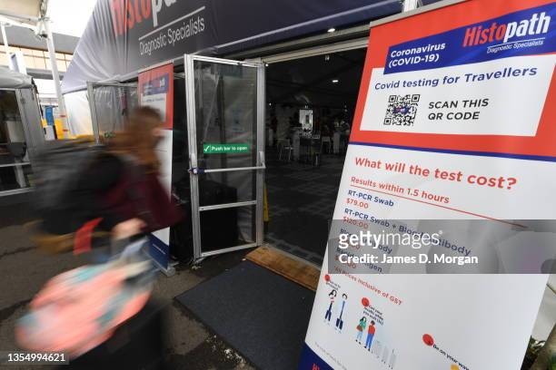 Passengers wait outside an on-site pre-departure testing clinic for COVID-19 beside the departures hall at Sydney Airport on November 23, 2021 in...