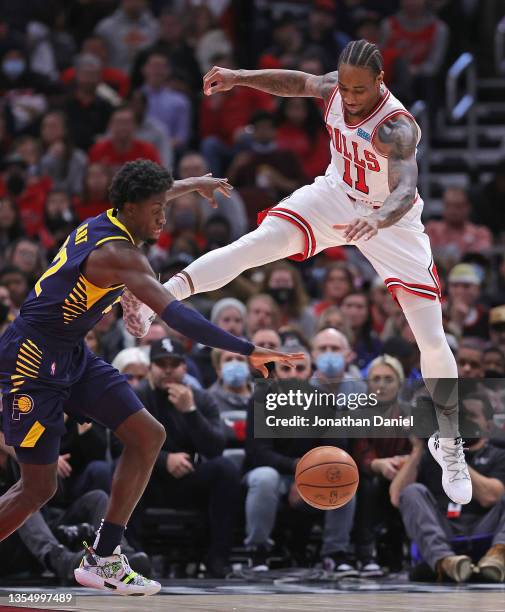 Caris LeVert of the Indiana Pacers knocks the ball away from DeMar DeRozan of the Chicago Bulls at the United Center on November 22, 2021 in Chicago,...