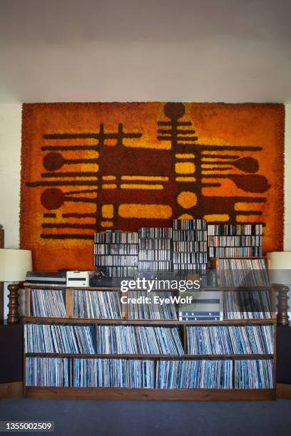 large home collector record collection with sixties carpet hanging on wall behind. - colorful cd stock pictures, royalty-free photos & images