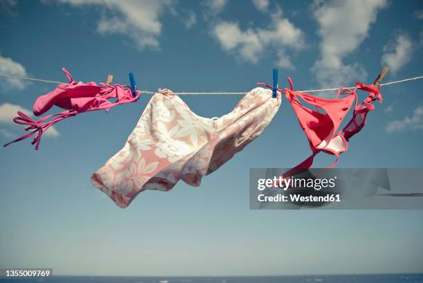 bikini's on clothesline during sunny day - costume foto e immagini stock